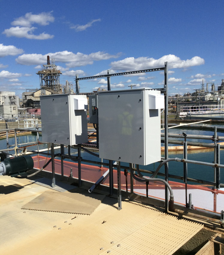 A pair of control panels installed at a water plant jobsite over one of the outdoor water tanks.